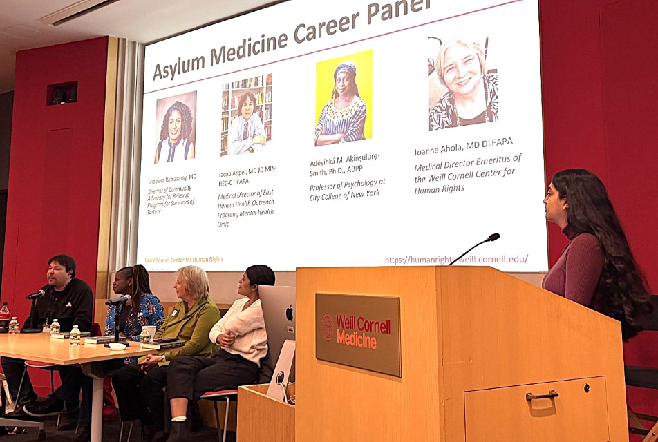 Photo of people at a table and at a podium