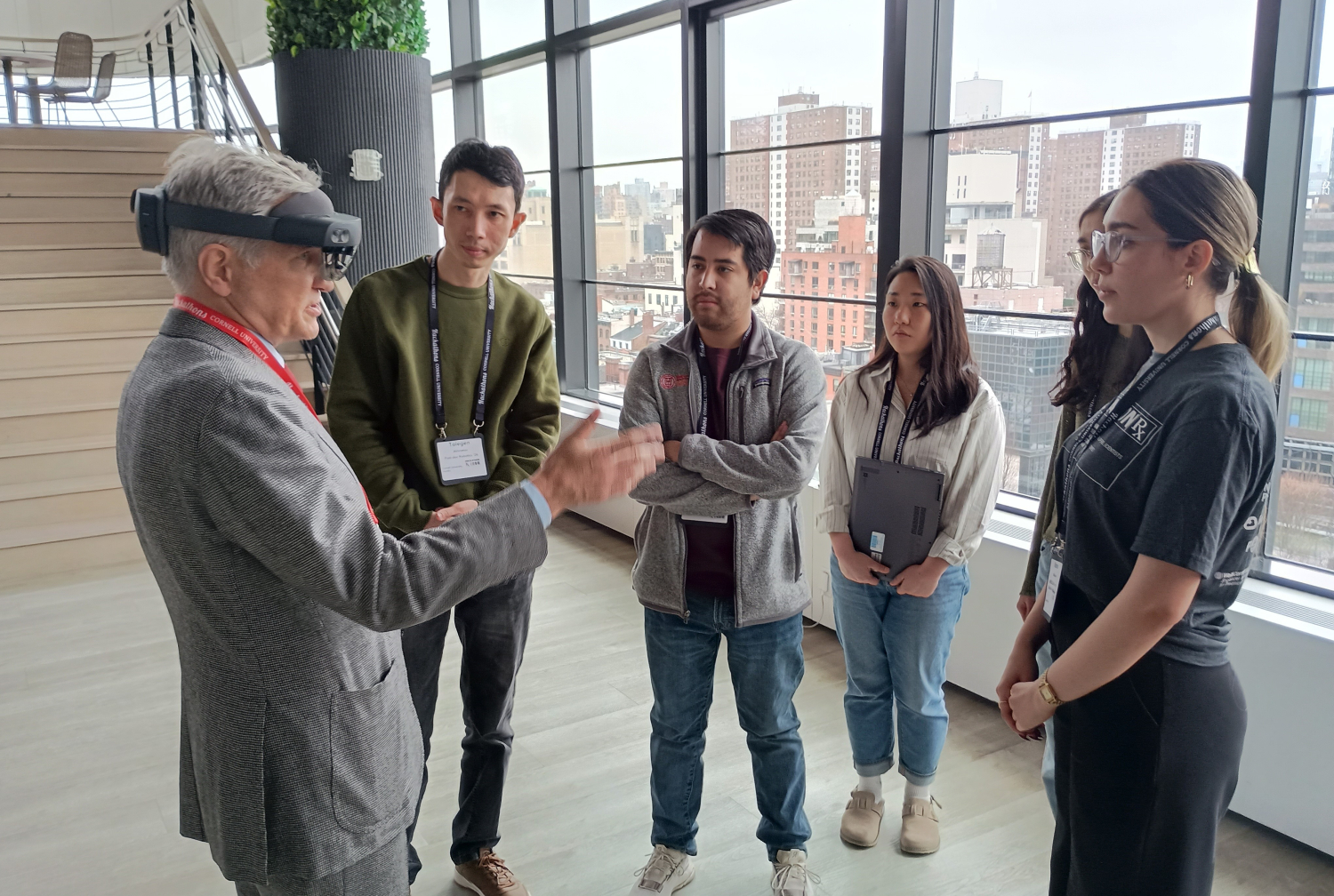 A group of students standing around a man wearing a virtual reality headset