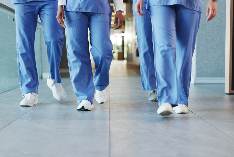 photo of the legs of people wearing scrubs walking in a hallway