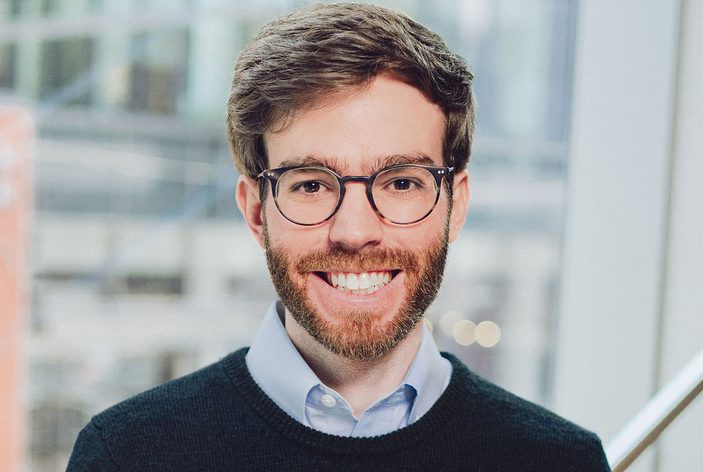Headshot of a man in front of a window