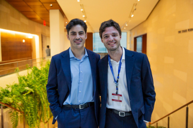 Two young Caucasian men wearing dark blue suits and pants