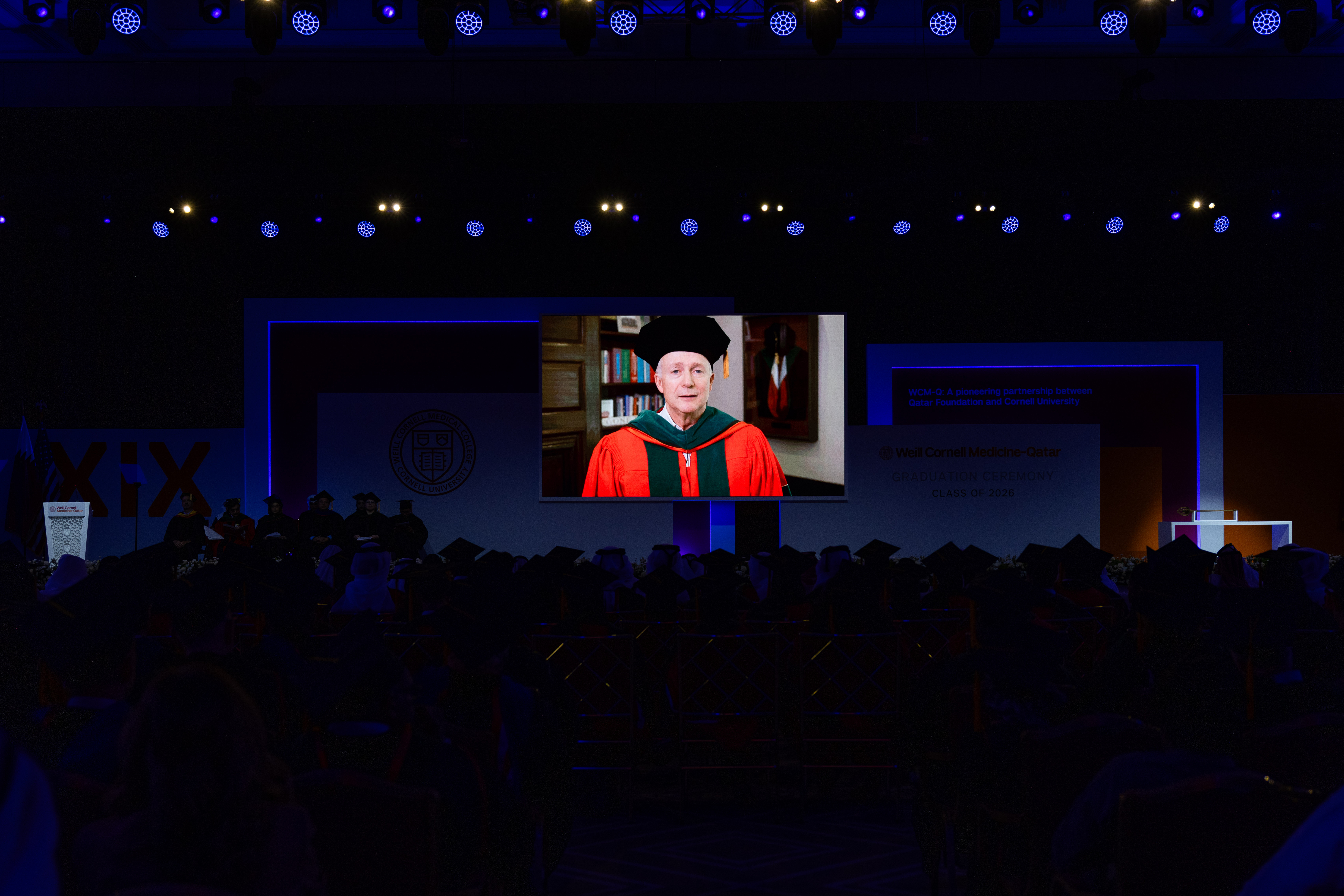 a man on a screen addressing an audience