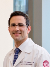 a man in a white coat smiling