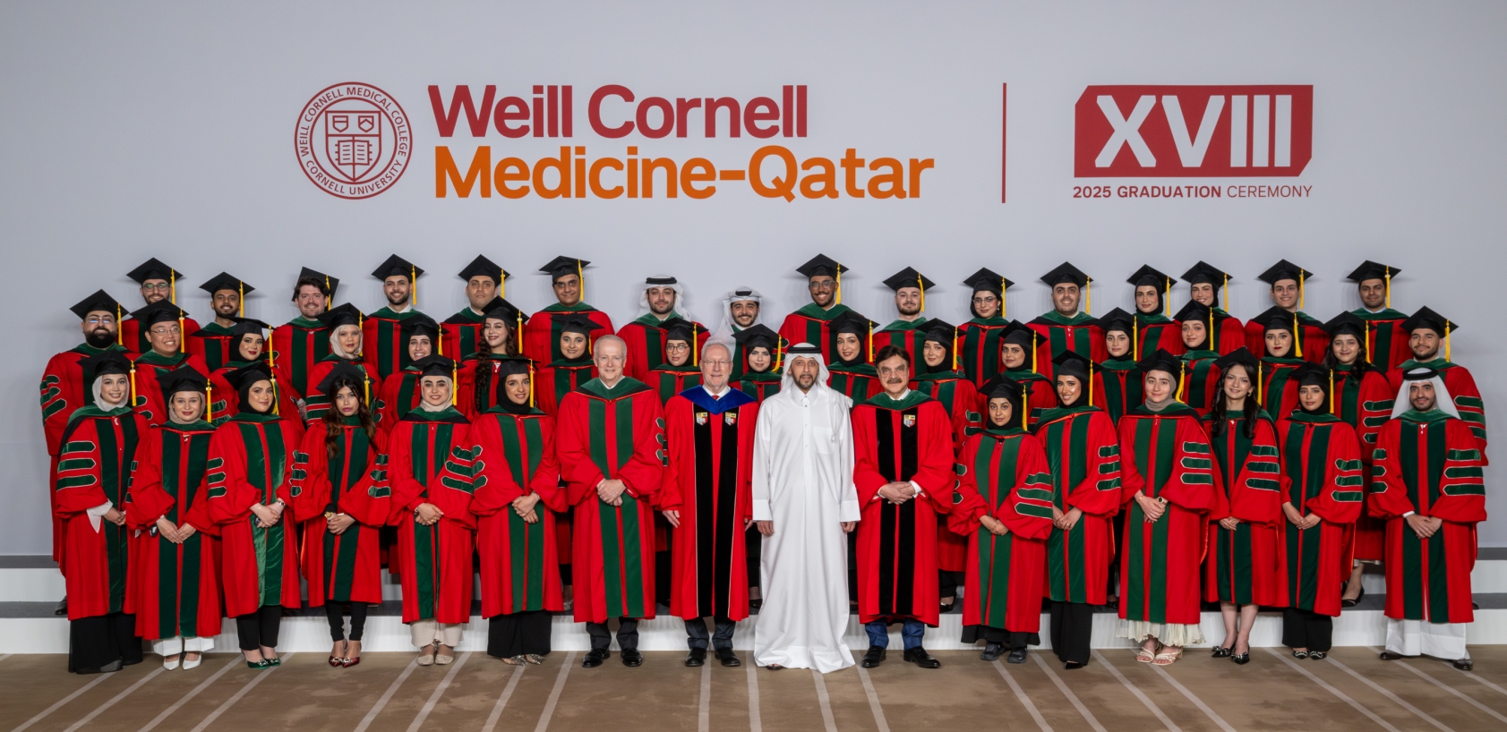 A group of graduating medica students with institutional leadership posing for a group photo
