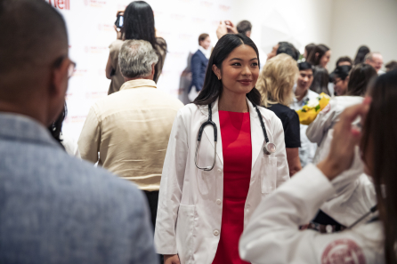 A woman wearing a red dress and white medical coat
