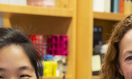 Two women pose for a photo in a lab