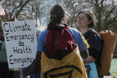 woman holding poster saying climate emergency equals health emergency