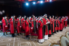 Students wearing graduation regalia giving an oath
