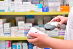 hands holding scanner and pill bottle