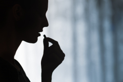 silhouette of a woman taking a pill
