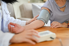 female doctor taking blood pressure of an older woman