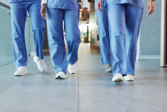 photo of the legs of people wearing scrubs walking in a hallway